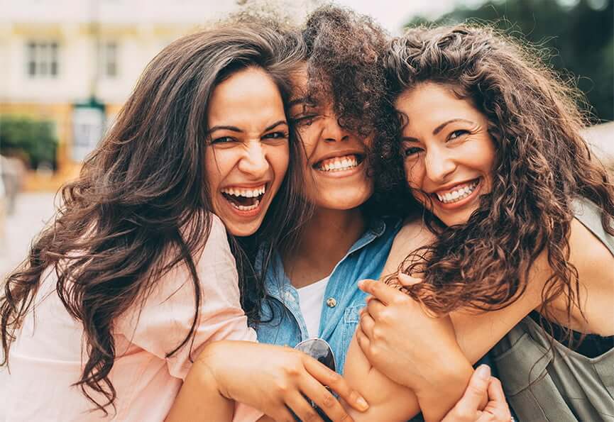 group of three smiling female friends