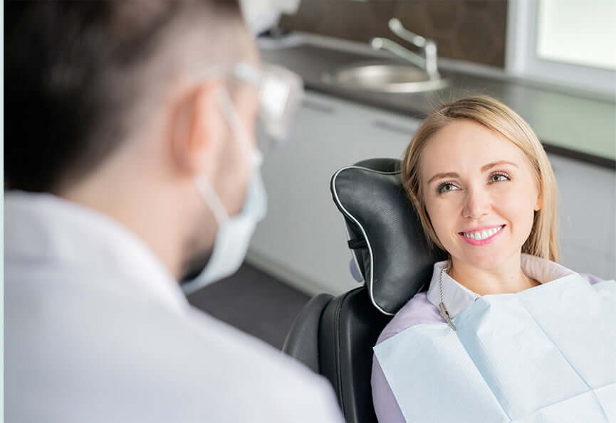 smiling woman talking with her dentist