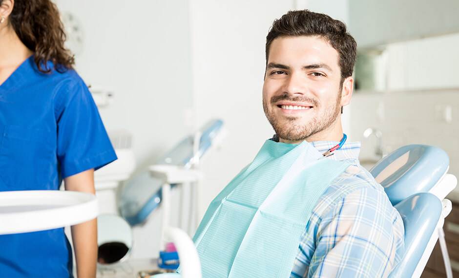 smiling man sitting in a dental chair