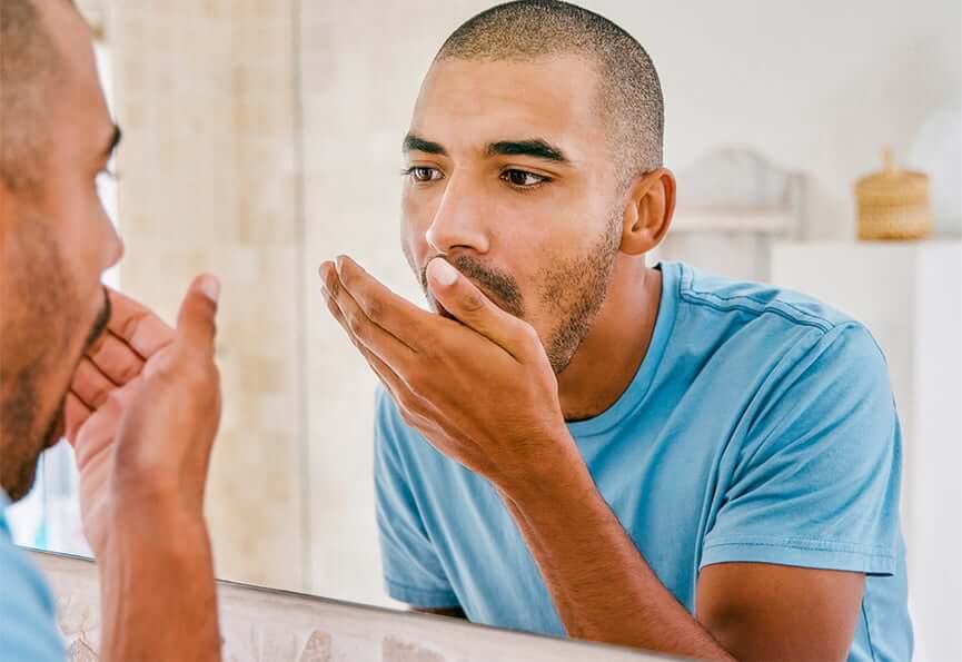 man checking to see if his breath stinks